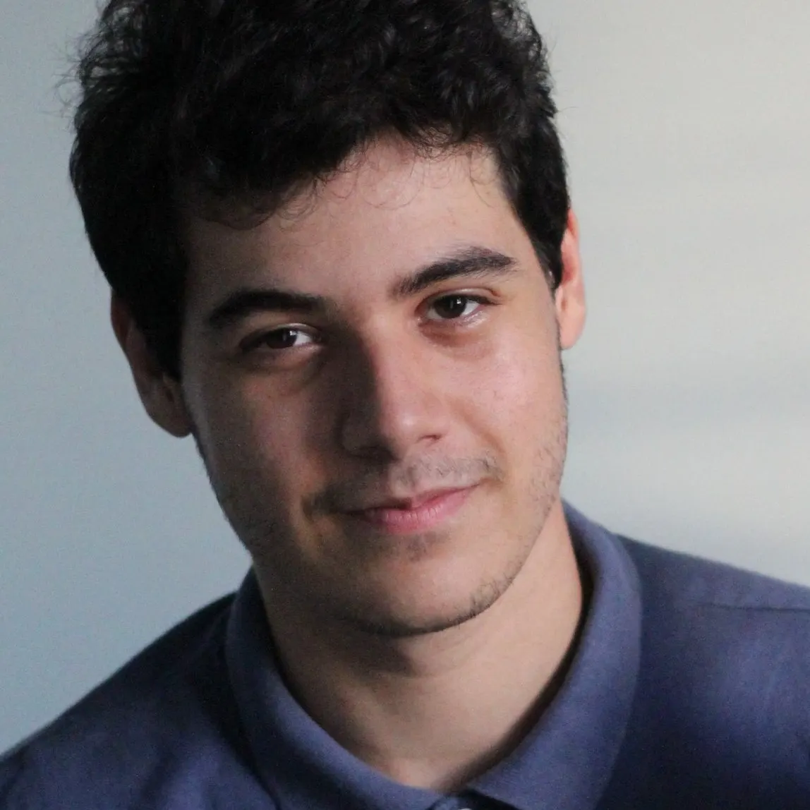 Lorran Sebastian, psicólogo clínico, sorrindo, de camisa polo azul